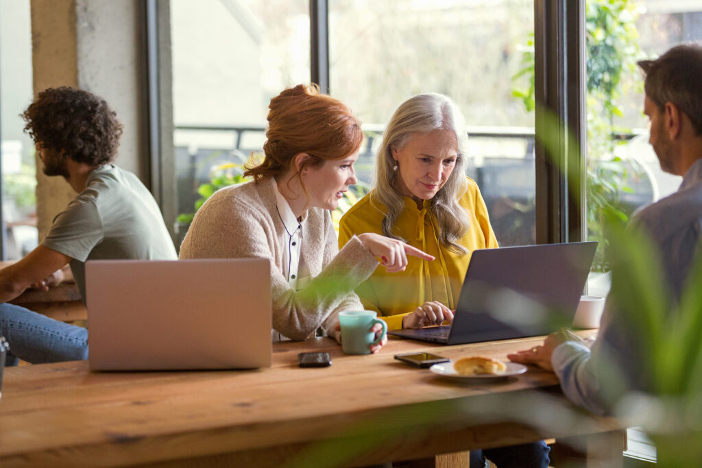Quatre personnes dans un bureau travaillant sur des ordinateurs portables.