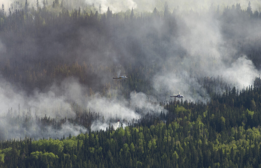 A helicopter drops a bucket of water on the Chuckegg Creek wildfire west of High Level, Alberta