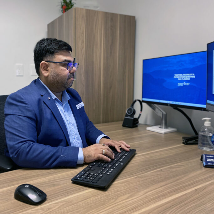 A man sits at a desk working on a computer