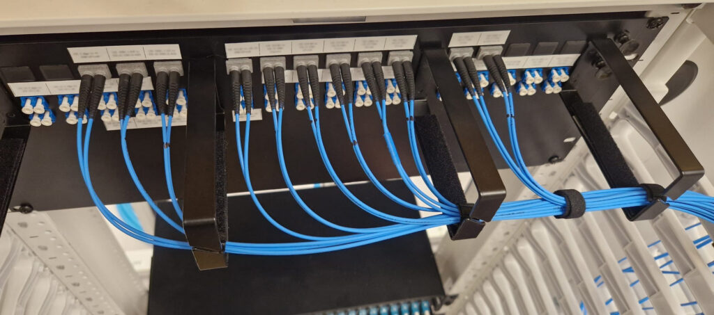Gros plan de câbles bleus branchés à de l’équipement noir.